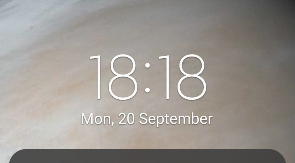 A mobile phone clock showing 18:18 an angel number